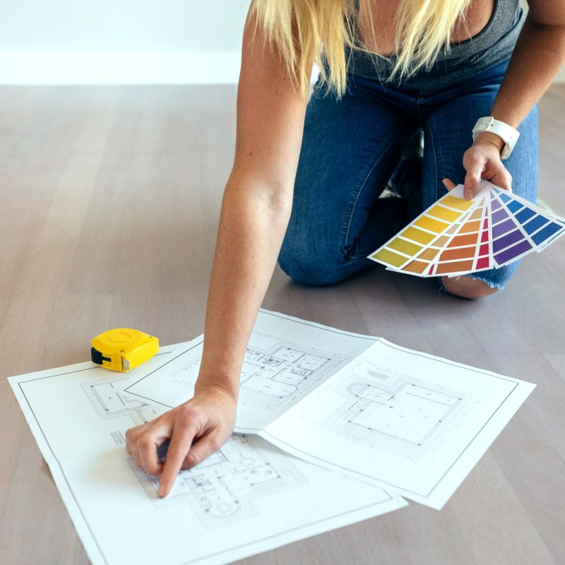 Young woman looking house plans on the floor